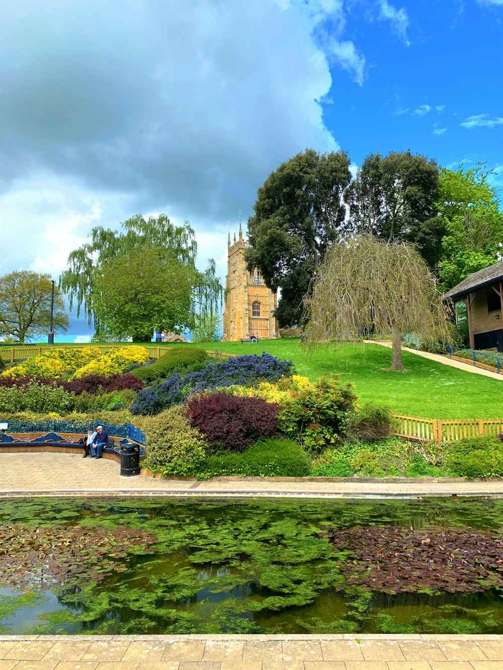 people sitting on bench near trees and building during daytime