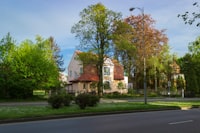 brown and white concrete house near green trees during daytime