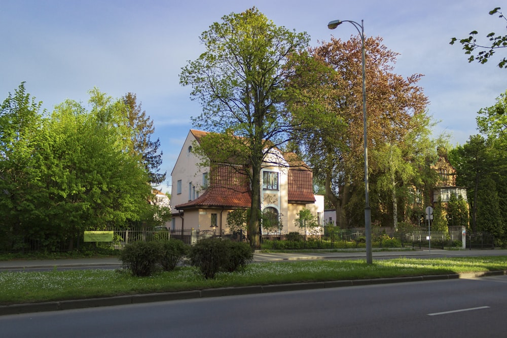 brown and white concrete house near green trees during daytime