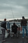 man in black jacket and blue denim jeans standing beside man in black jacket