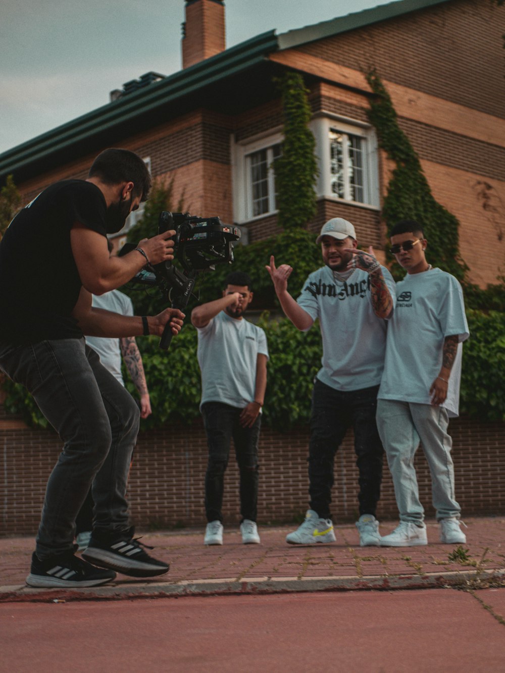 man in black crew neck t-shirt and gray pants standing beside man in white t