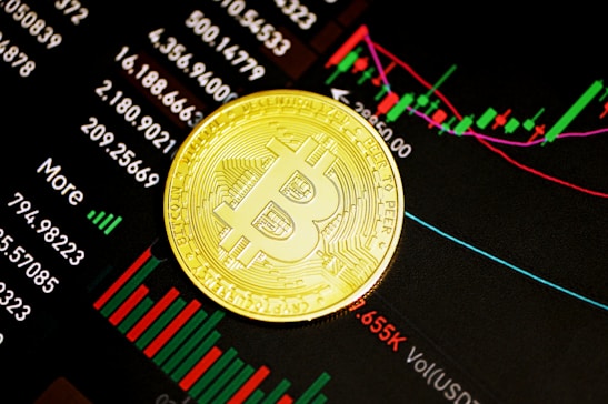 A gold Bitcoin coin resting on a digital display of financial market data, showcasing various stock tickers, charts, and numerical indicators.