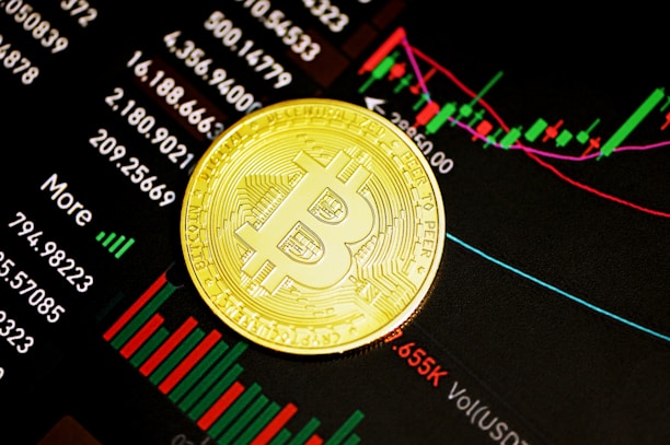 A gold Bitcoin coin resting on a digital display of financial market data, showcasing various stock tickers, charts, and numerical indicators.