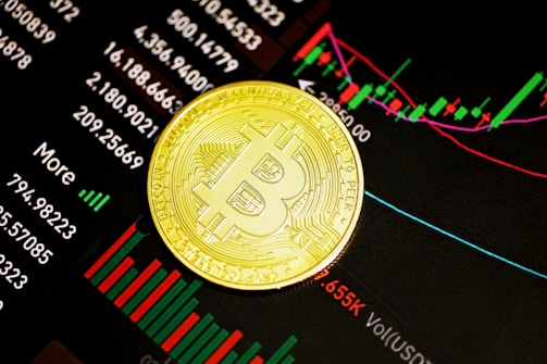 A gold Bitcoin coin resting on a digital display of financial market data, showcasing various stock tickers, charts, and numerical indicators.