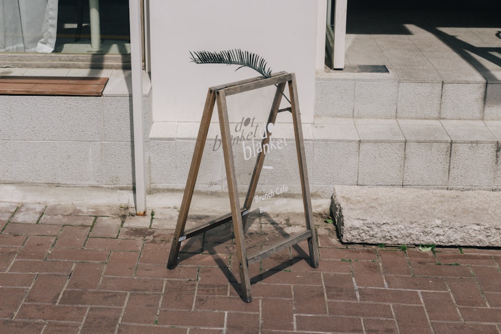 brown wooden folding ladder leaning on white concrete wall