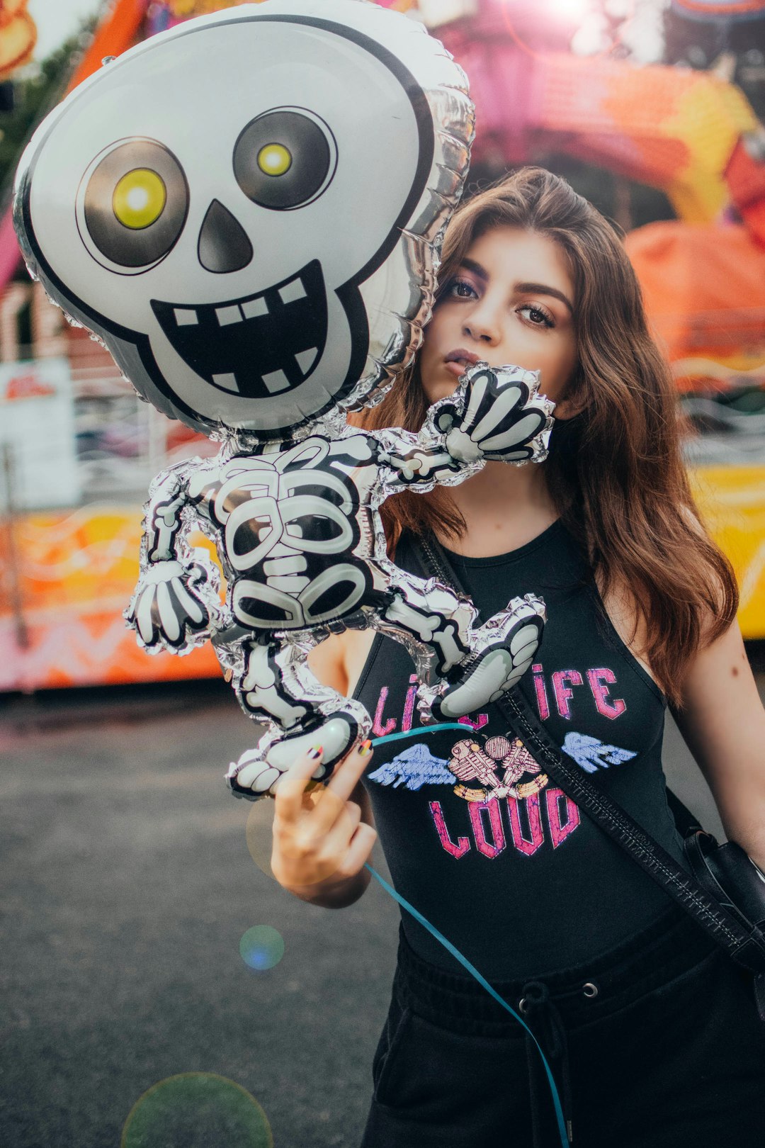 woman in black tank top holding white and black skull print balloon