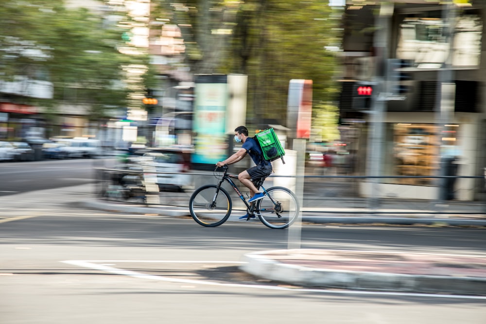 낮 동안 도로에서 자전거를 타는 녹색 셔츠를 입은 남자