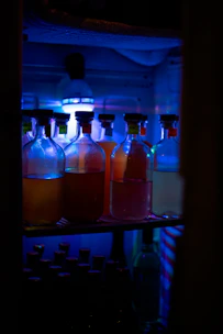 Close-up of industrial chemical containers with deep red bromine tones under soft lighting.