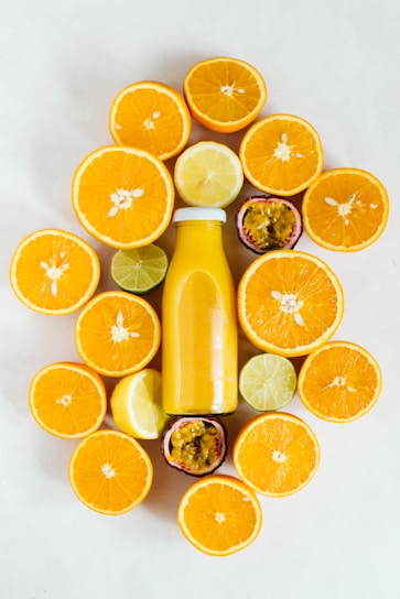Close-up of a vibrant citrusburn bottle surrounded by fresh citrus fruits on a rustic wooden table.