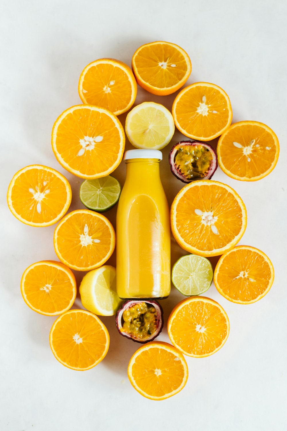 sliced orange fruit beside yellow liquid filled bottle