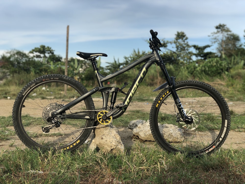 black and yellow mountain bike on brown rock during daytime