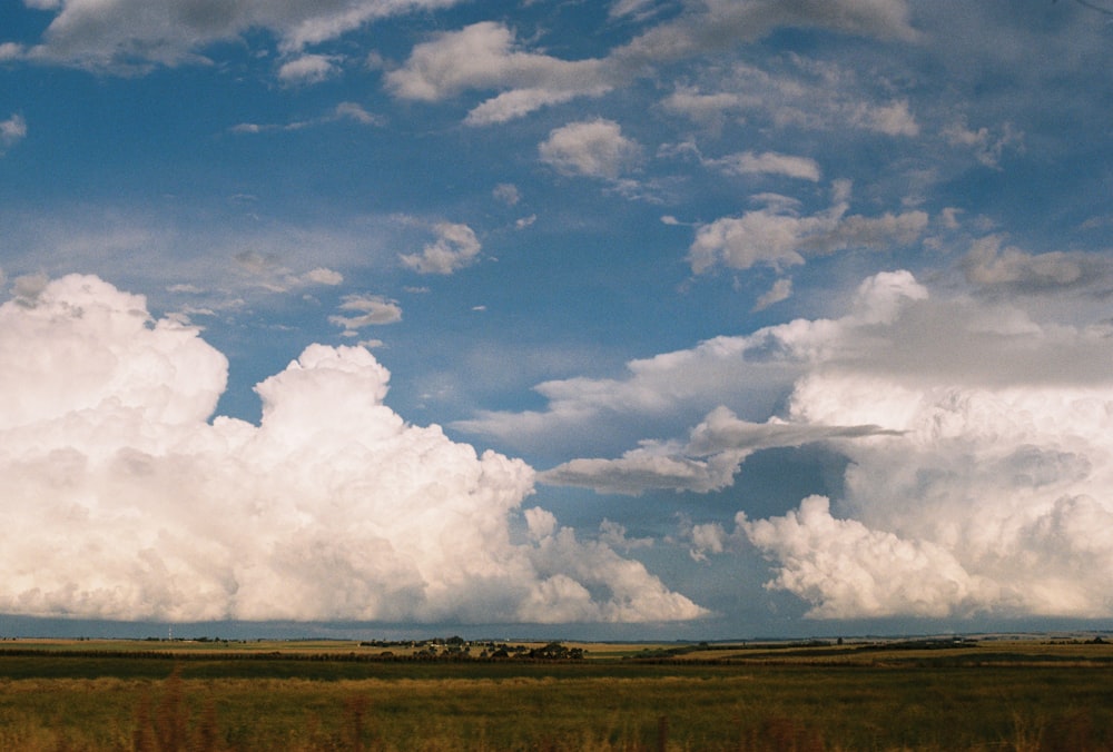 white clouds over brown field