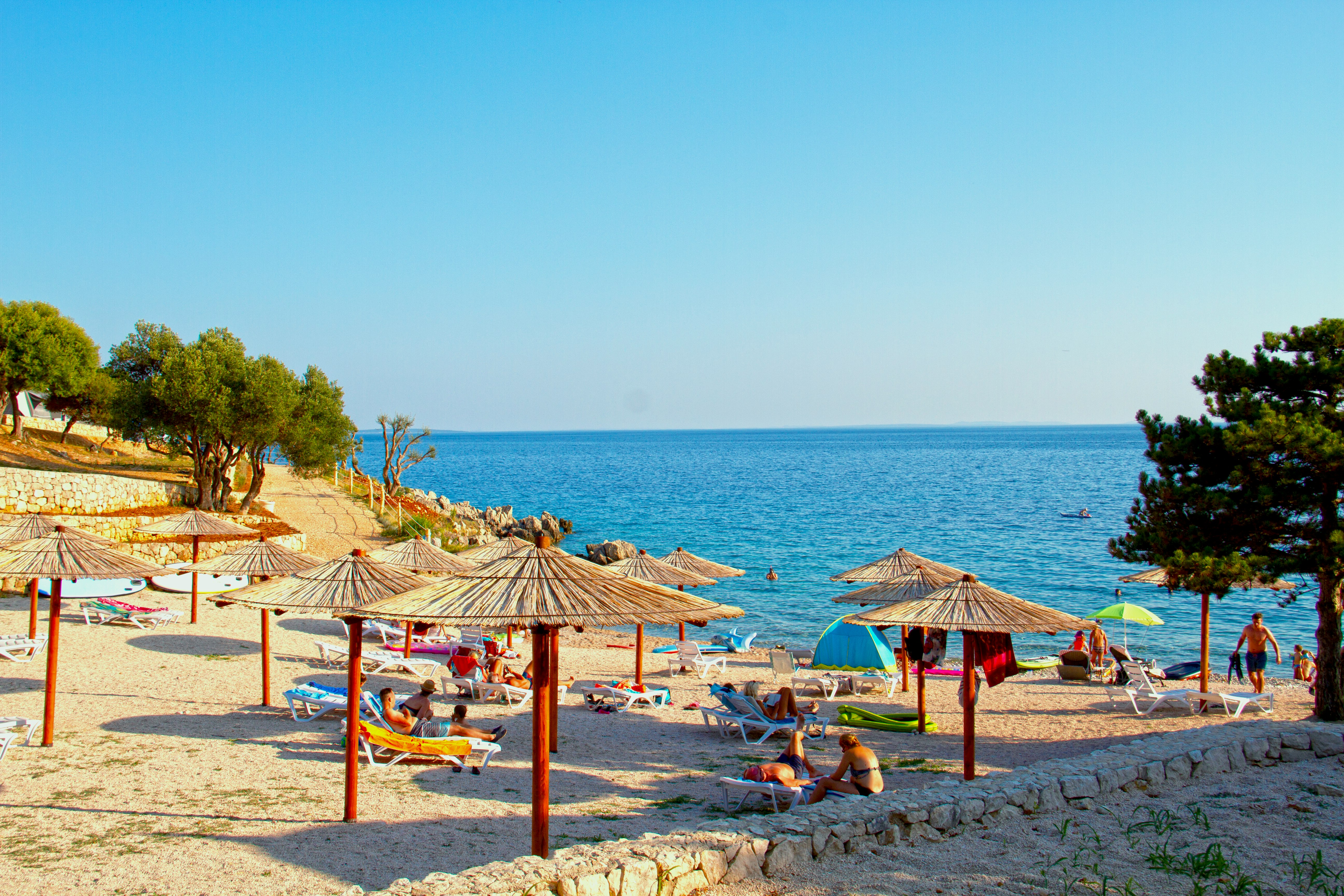 brown wooden beach lounge chairs on beach shore during daytime