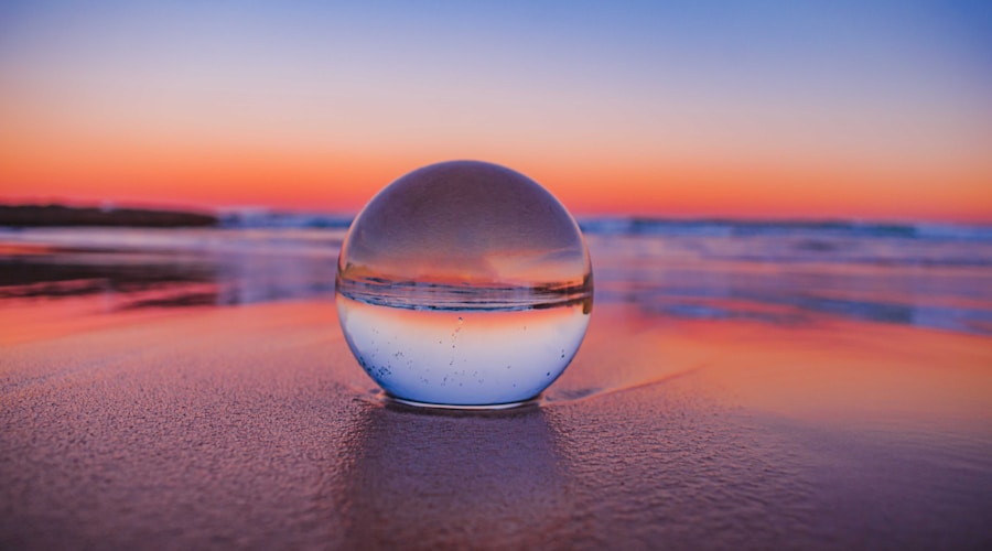 clear glass ball on gray sand during sunset