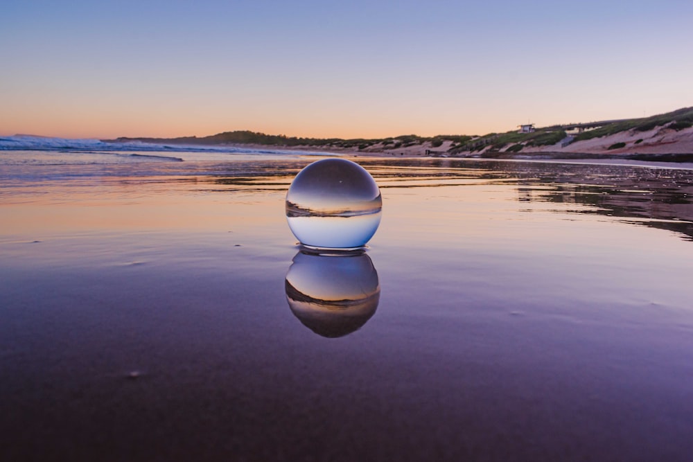 clear glass ball on water during daytime