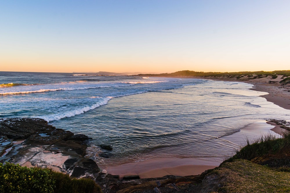 vagues de mer s’écrasant sur le rivage au coucher du soleil