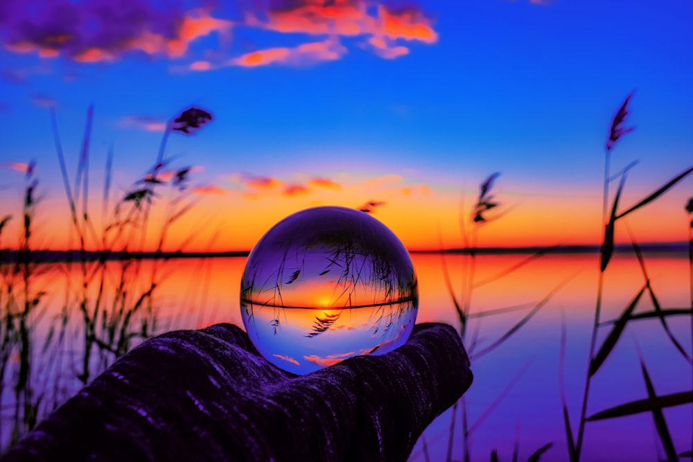 person holding ball during sunset