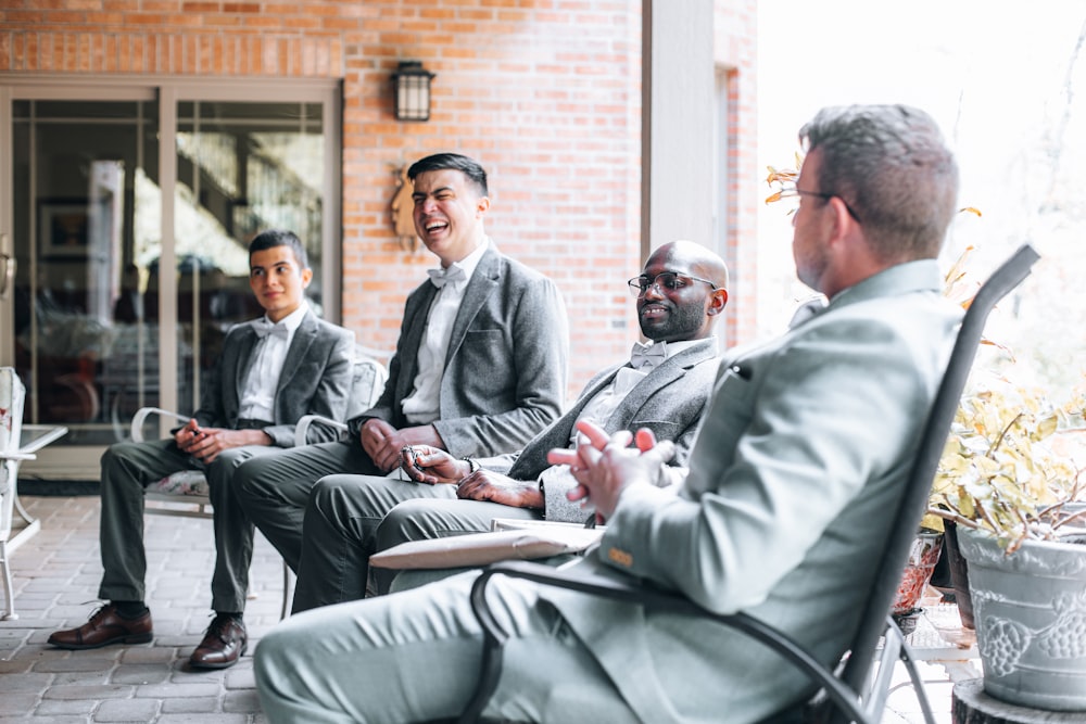 man in gray suit jacket sitting on chair beside man in gray suit jacket