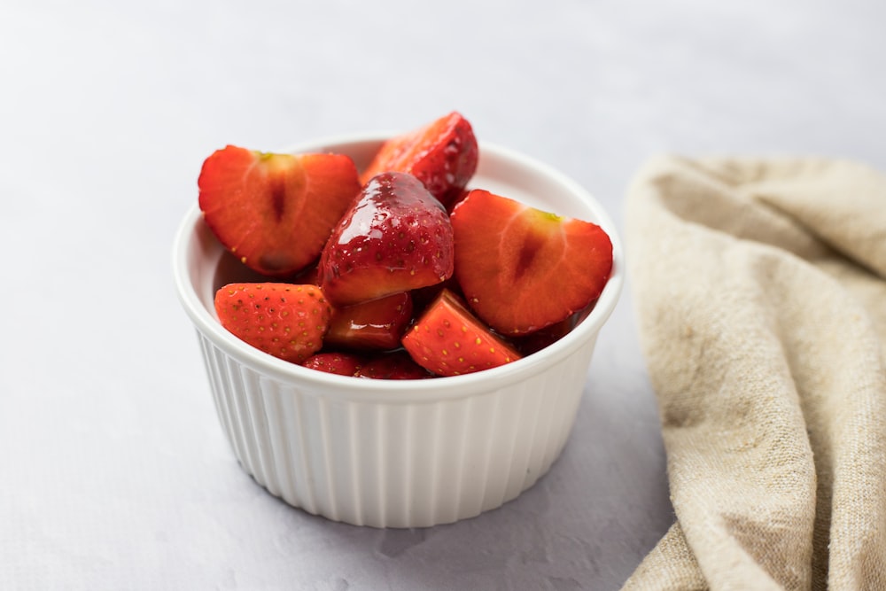 sliced strawberries in white ceramic bowl