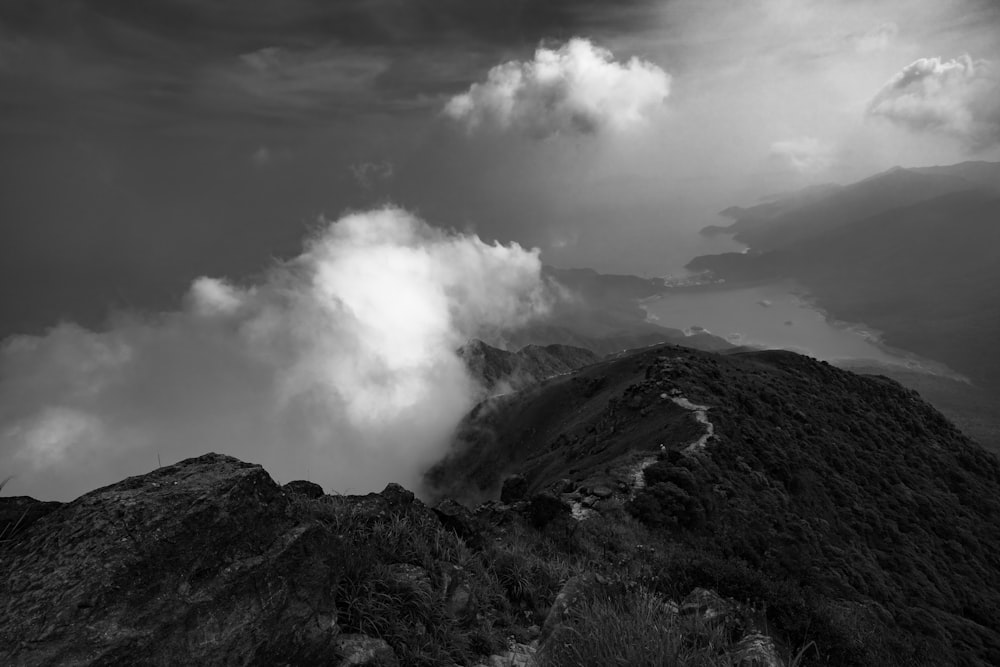 grayscale photo of mountain under cloudy sky