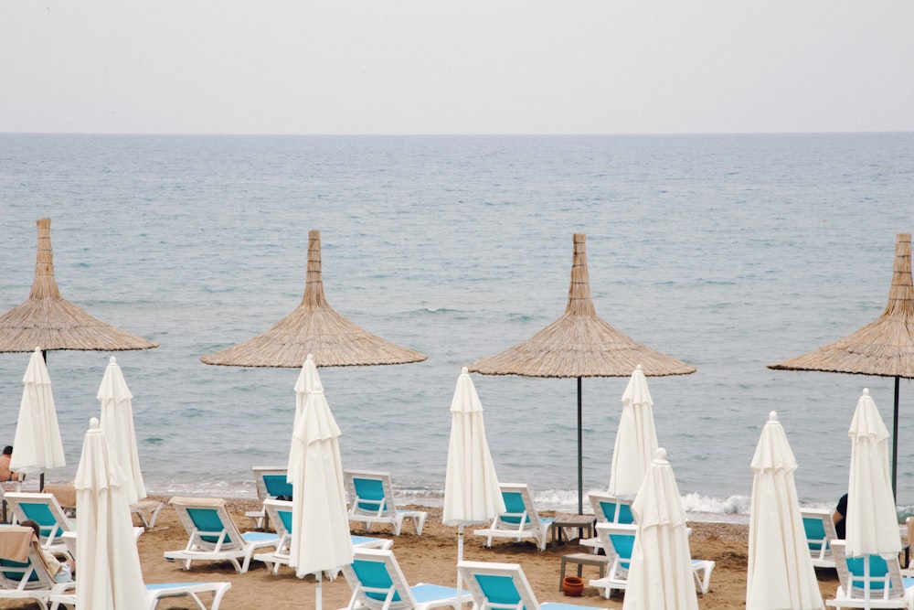 white and brown wooden lounge chairs on beach during daytime