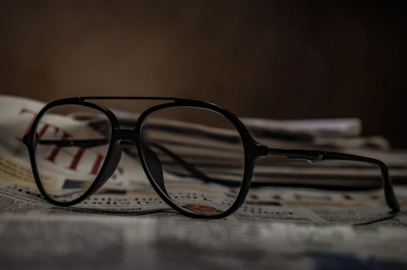 black framed eyeglasses on white printer paper