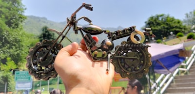 Close-up of hands holding a miniature electric mountain bike model.