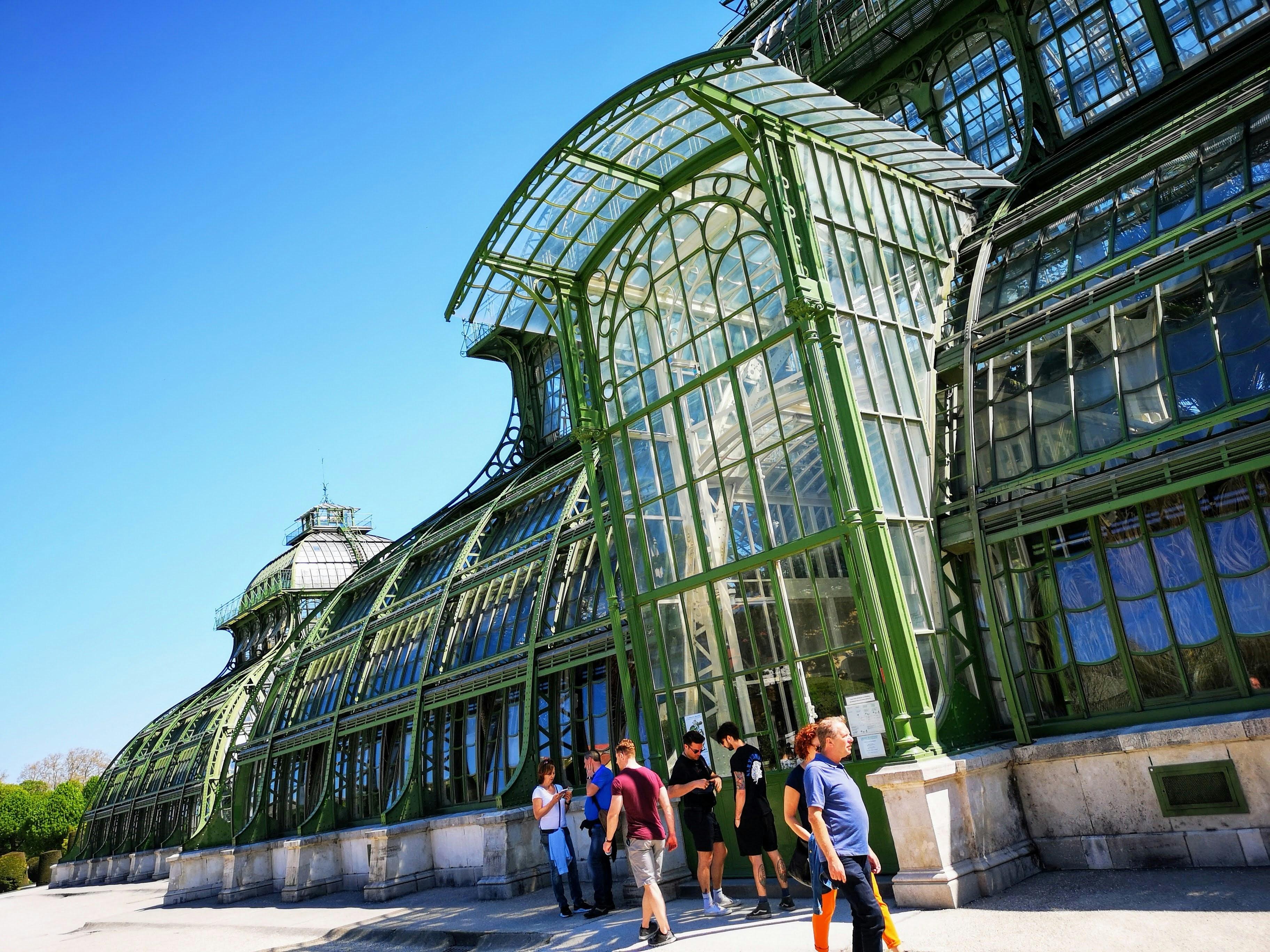 people walking on pathway near glass building during daytime