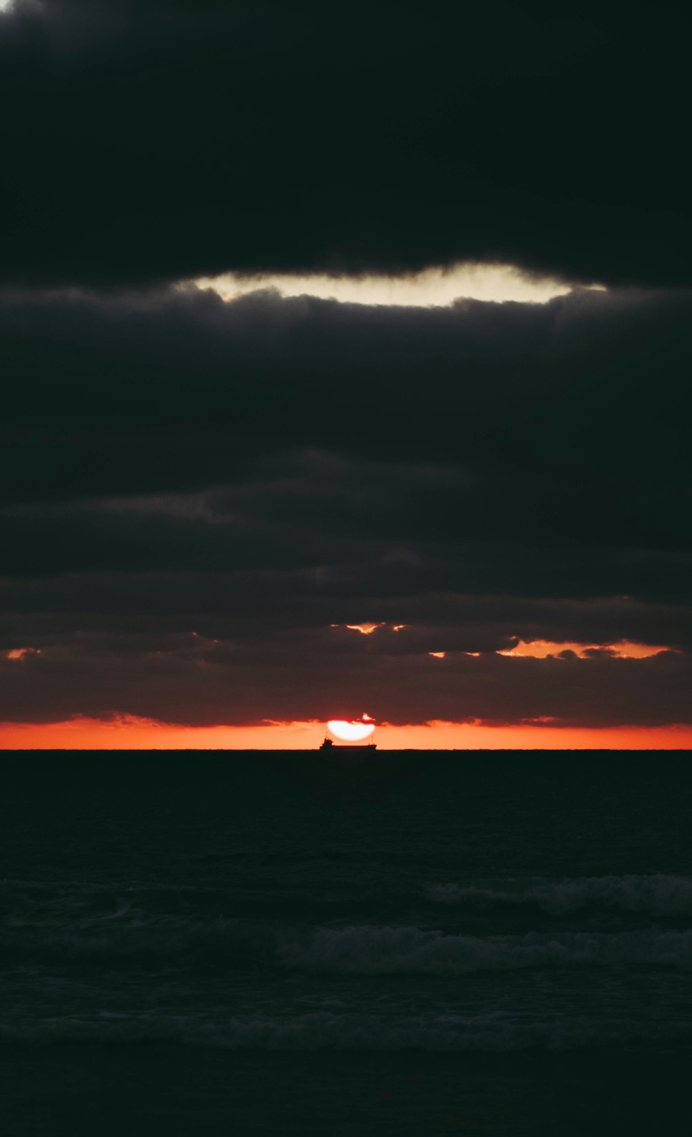 body of water under cloudy sky during sunset