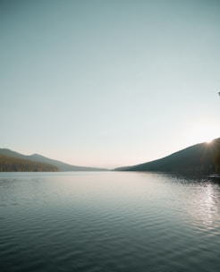 body of water near mountain during daytime