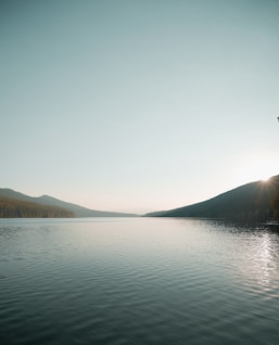 body of water near mountain during daytime