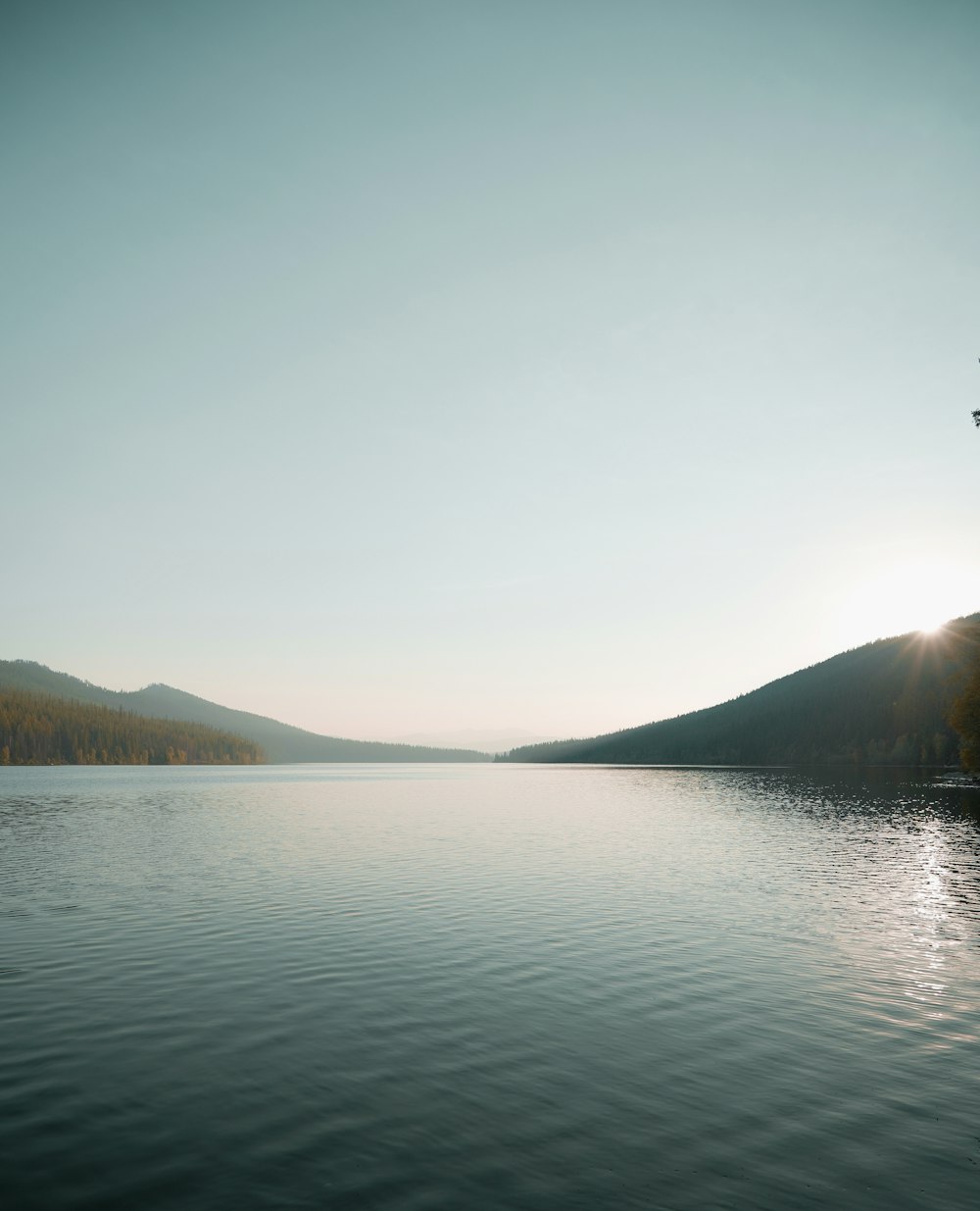 body of water near mountain during daytime