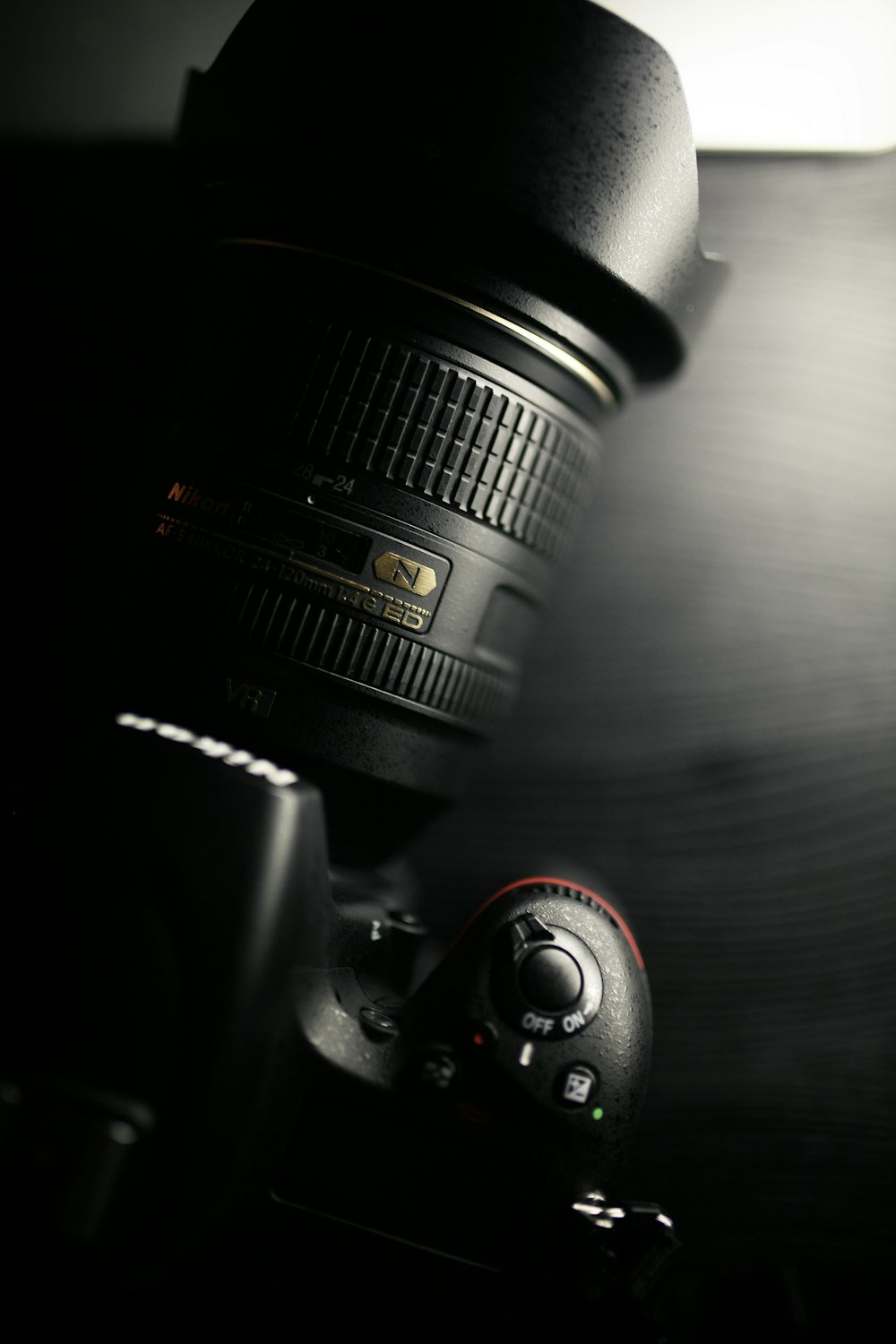 Fotocamera DSLR Nikon nera sul tavolo di legno marrone