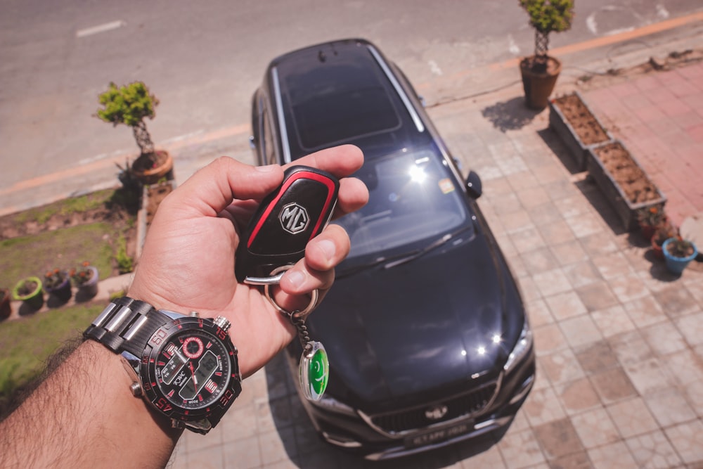 person holding black and red round digital watch