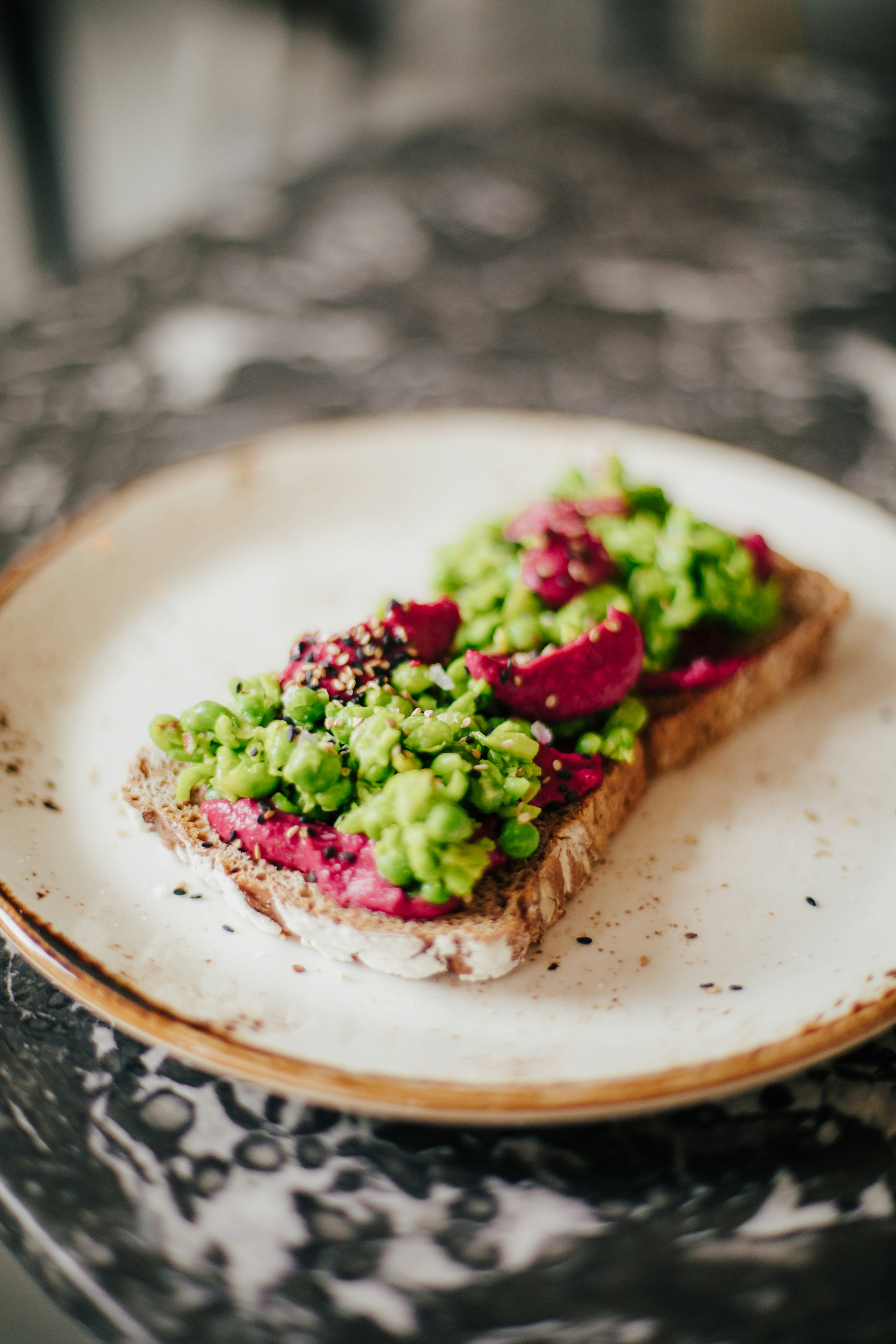 brown bread with green vegetable on white ceramic plate