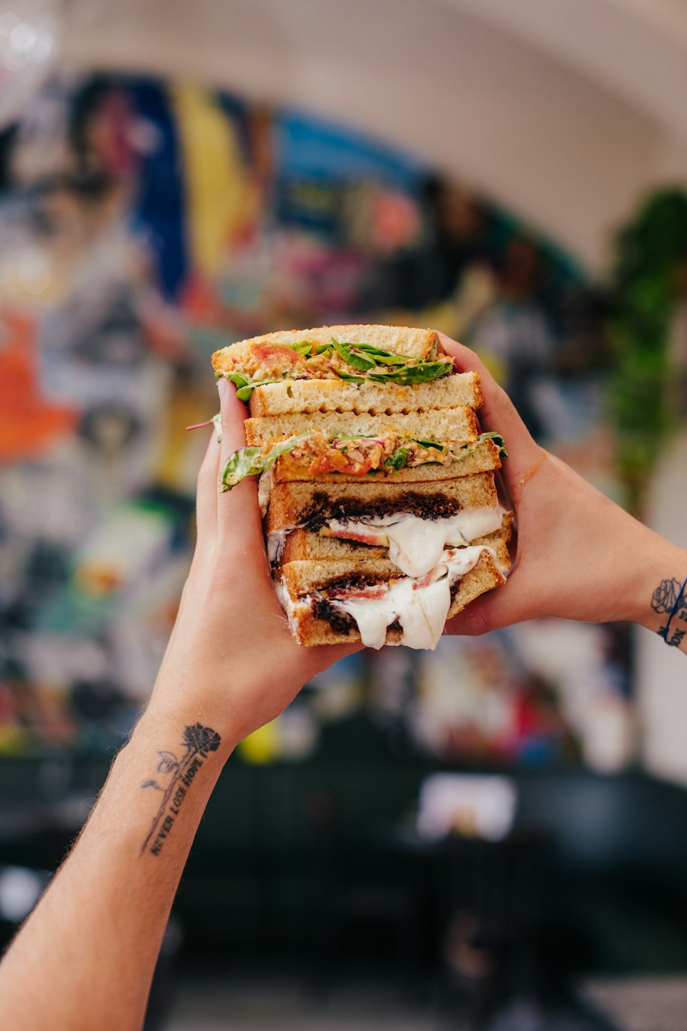 person holding burger with patty and cheese