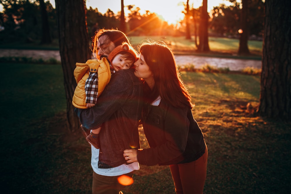 woman in brown long sleeve shirt carrying girl in white shirt