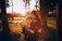 Smiling mother holding her child gently at a sunny park, feeling reassured.