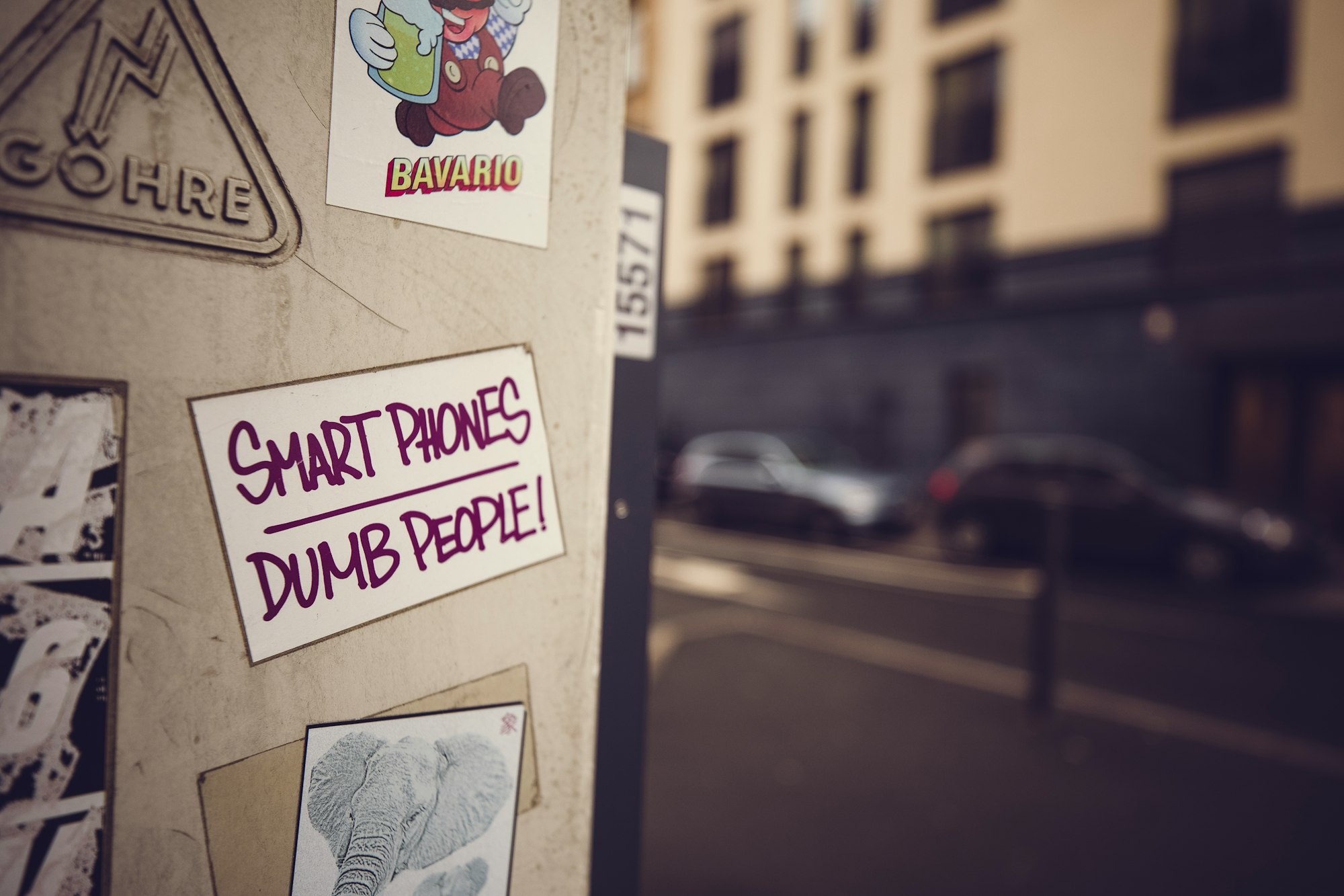 Urban street art sticker: SMART PHONES – DUMB PEOPLE – Technology criticism 