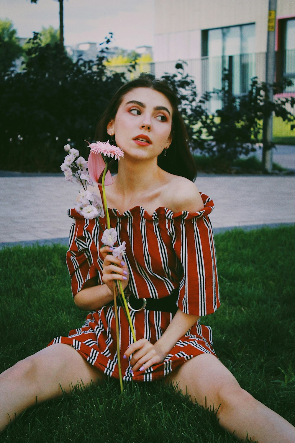 woman in red and white striped dress holding white flower