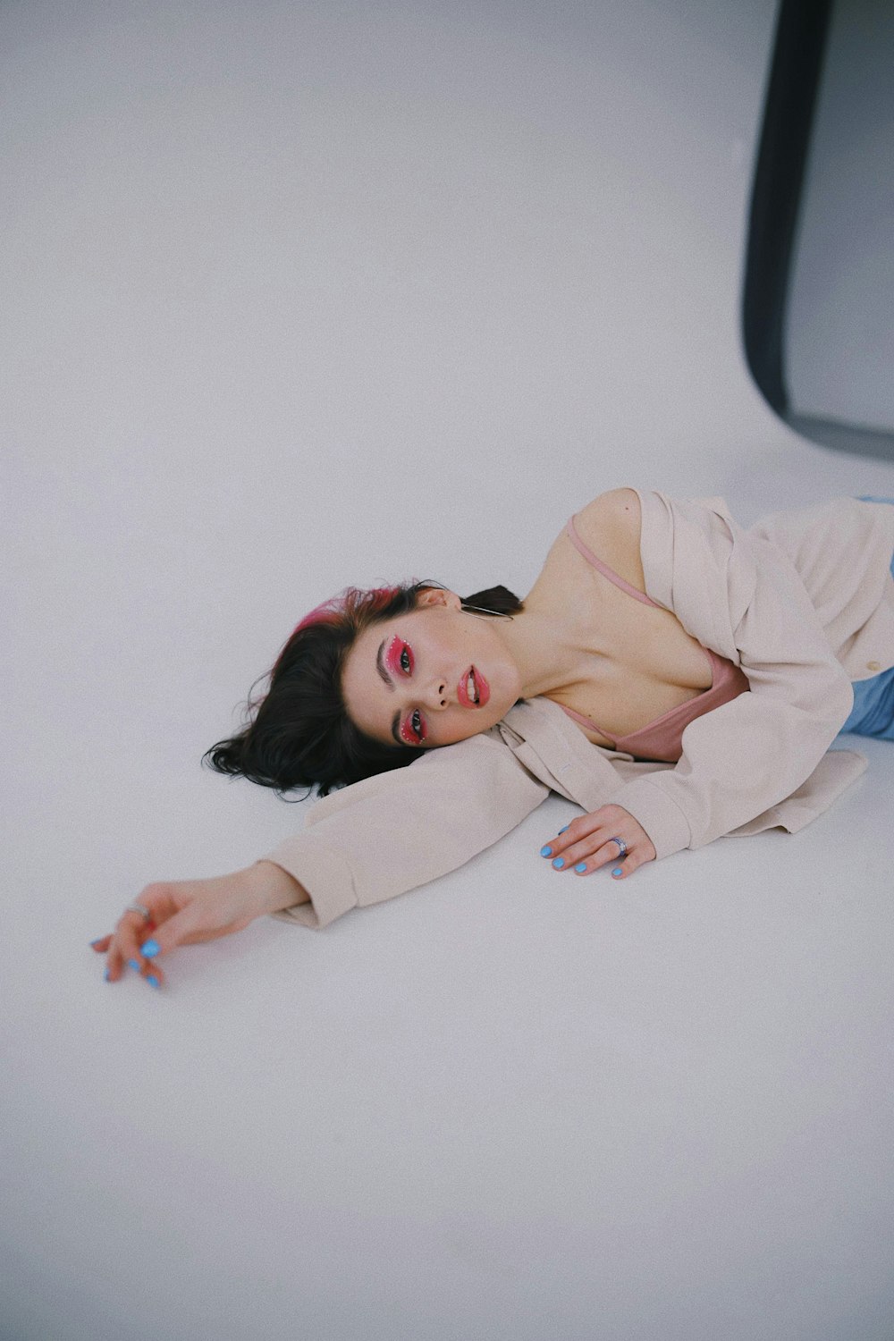 woman in white long sleeve shirt lying on white wall