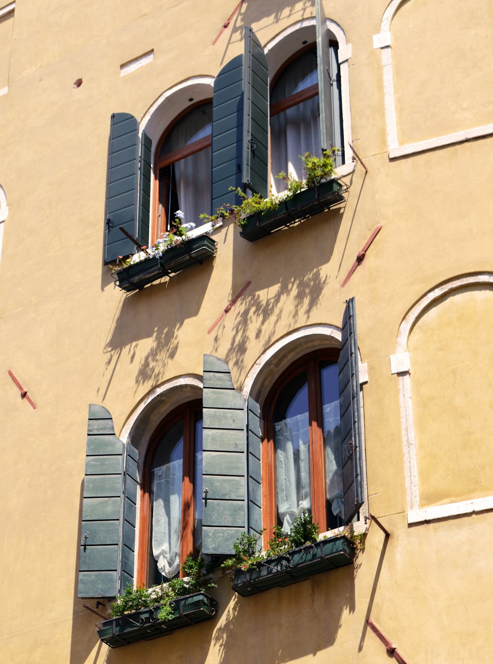 brown concrete building with green wooden windows