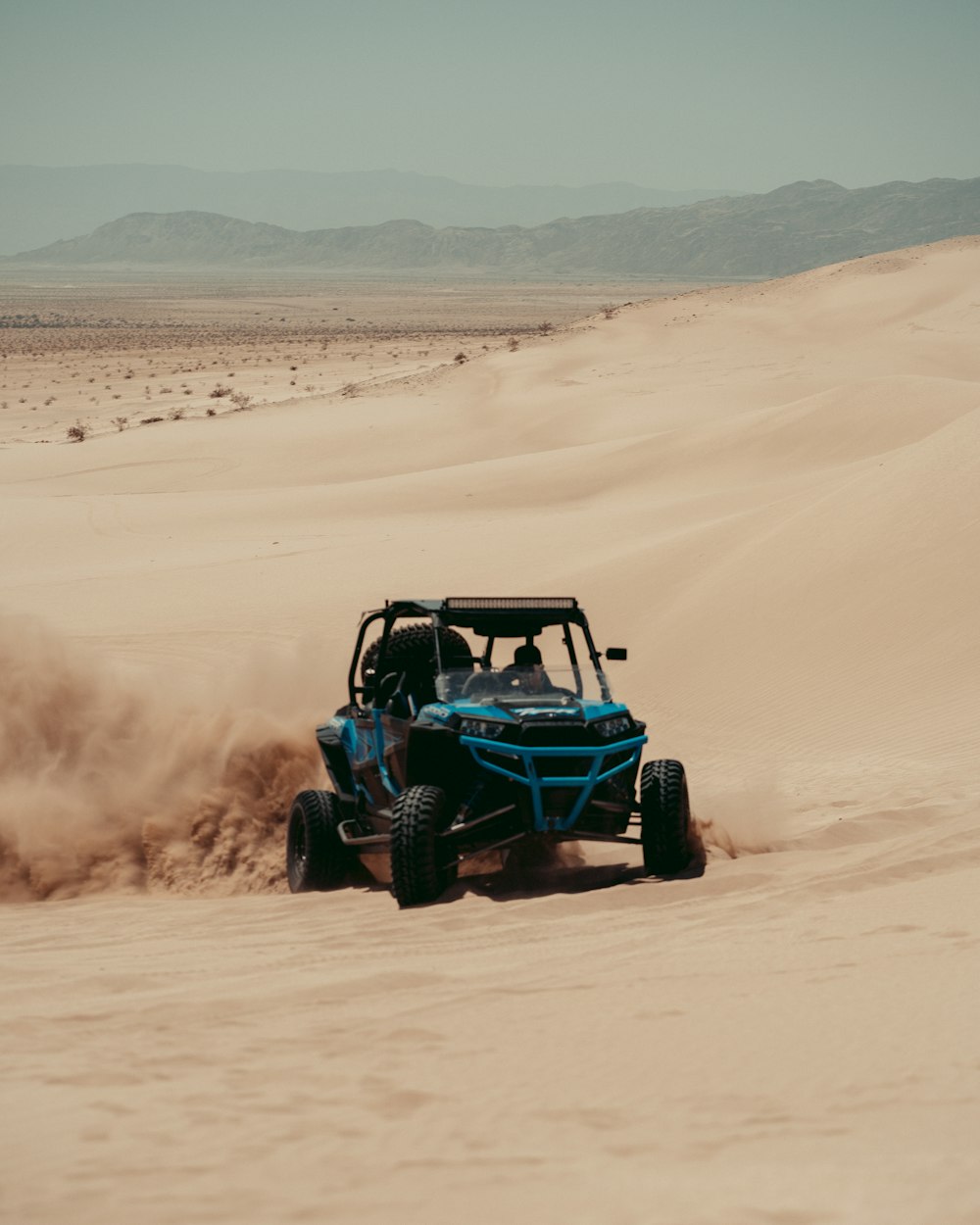 blue and black jeep wrangler on desert during daytime