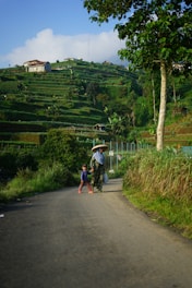 man in white shirt riding bicycle on road during daytime