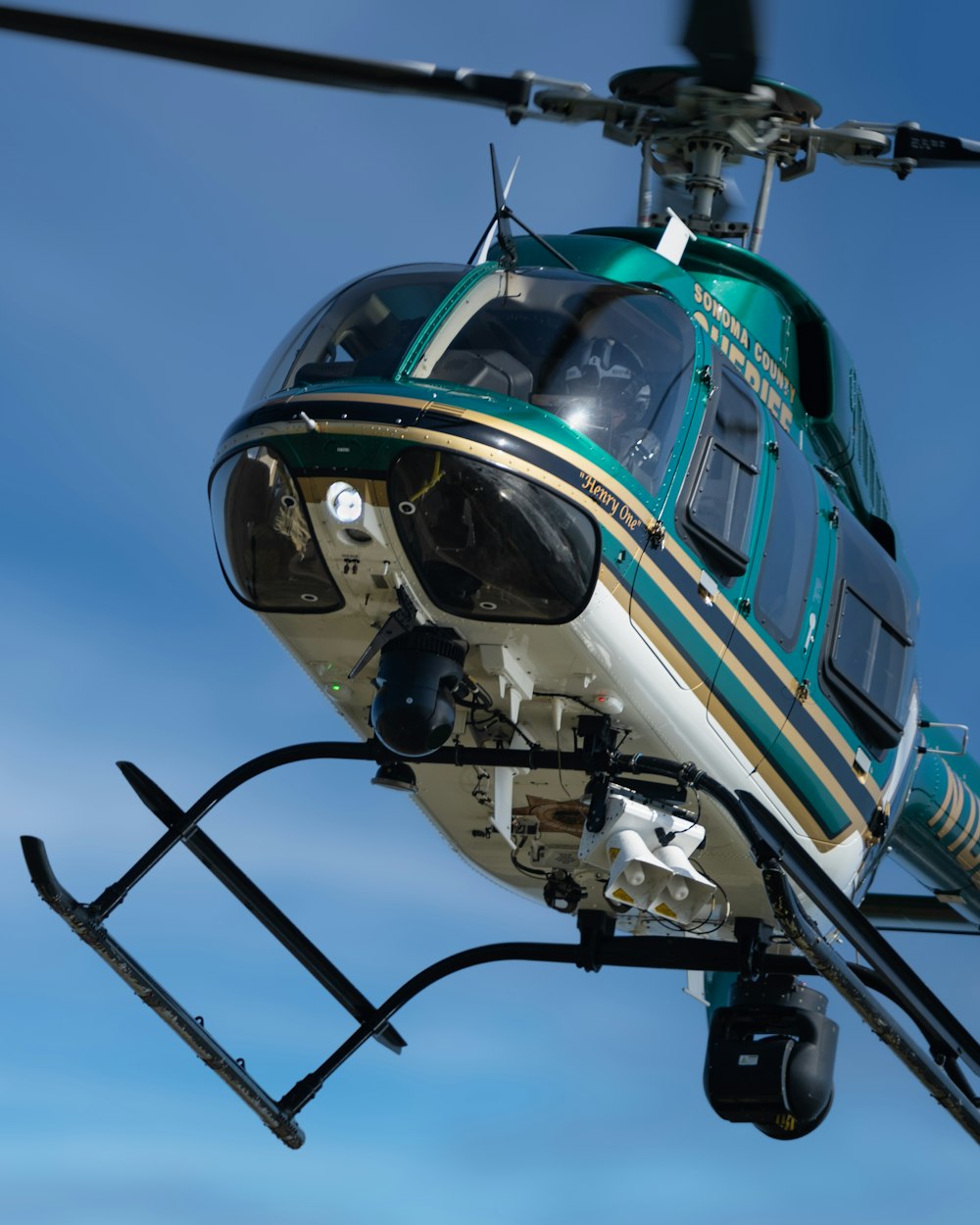 blue and white helicopter under blue sky during daytime