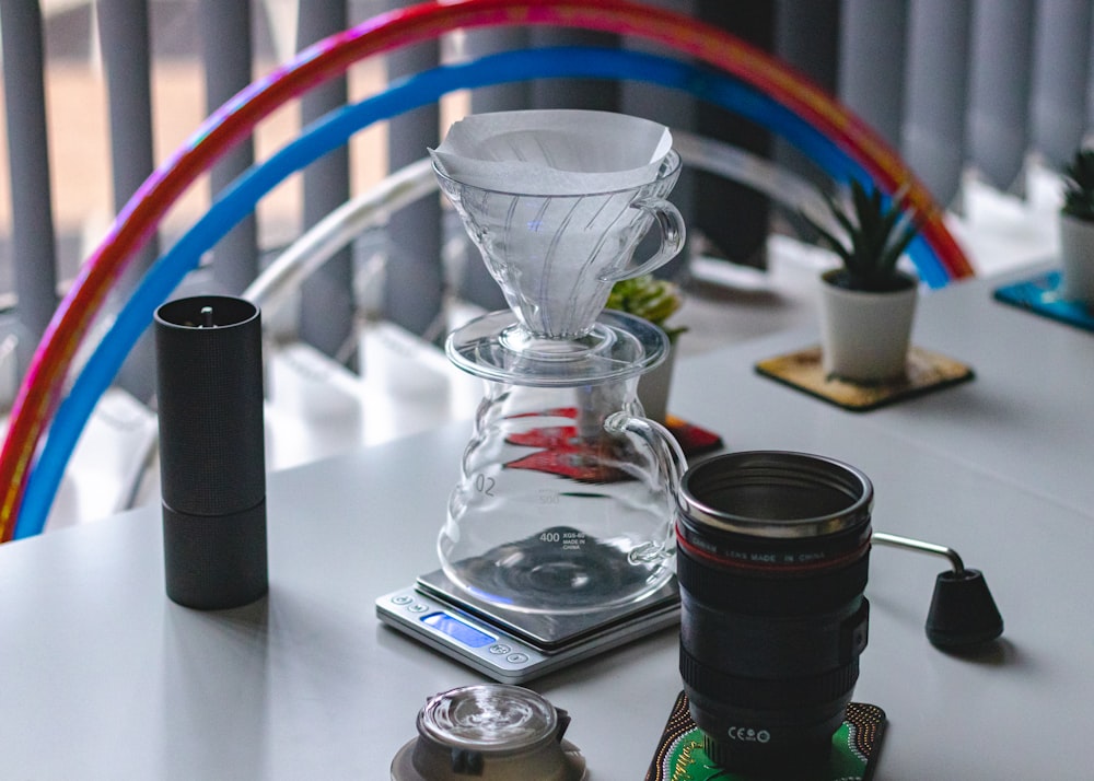 clear glass cup beside black and green bottle