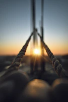 Close-up of ropes and sails softly blurred in the background, glowing in late afternoon light.