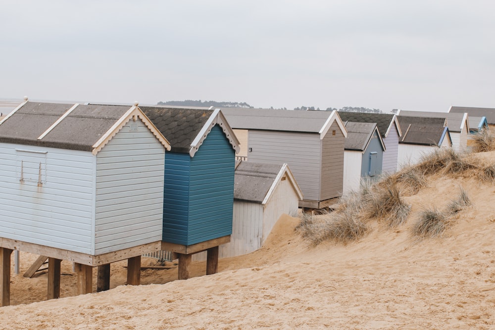 blue and white wooden house on brown sand during daytime