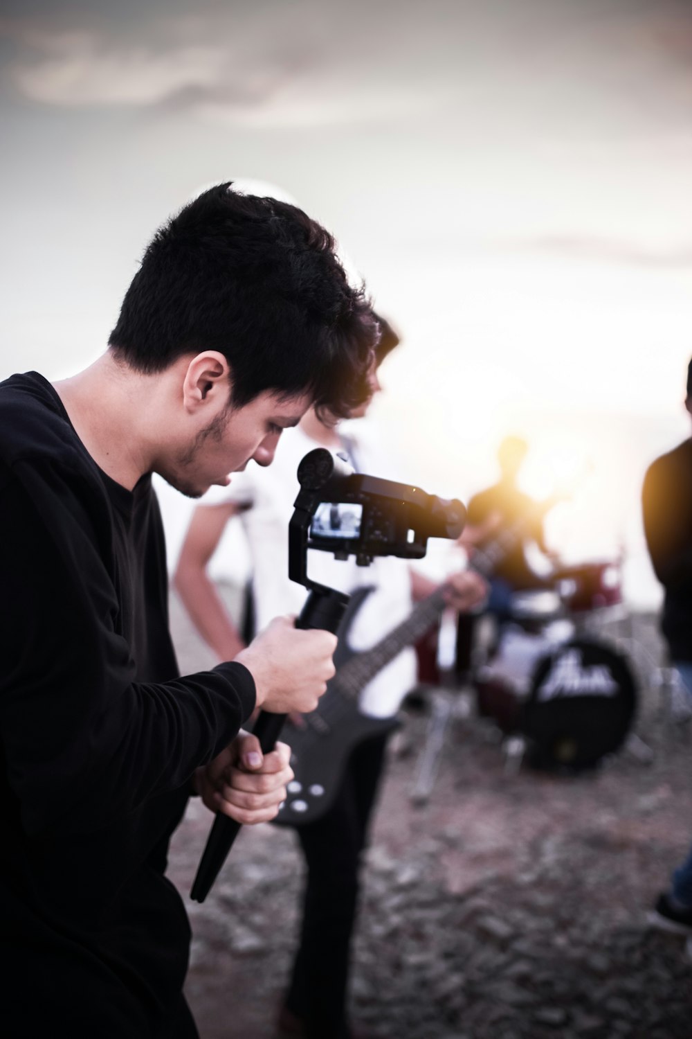 man in black long sleeve shirt holding black and gray video camera