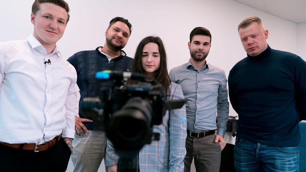 man in gray dress shirt holding black dslr camera